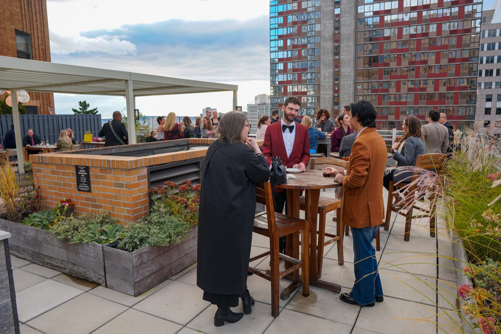 Guests mingling on a Brooklyn rooftop at sunset