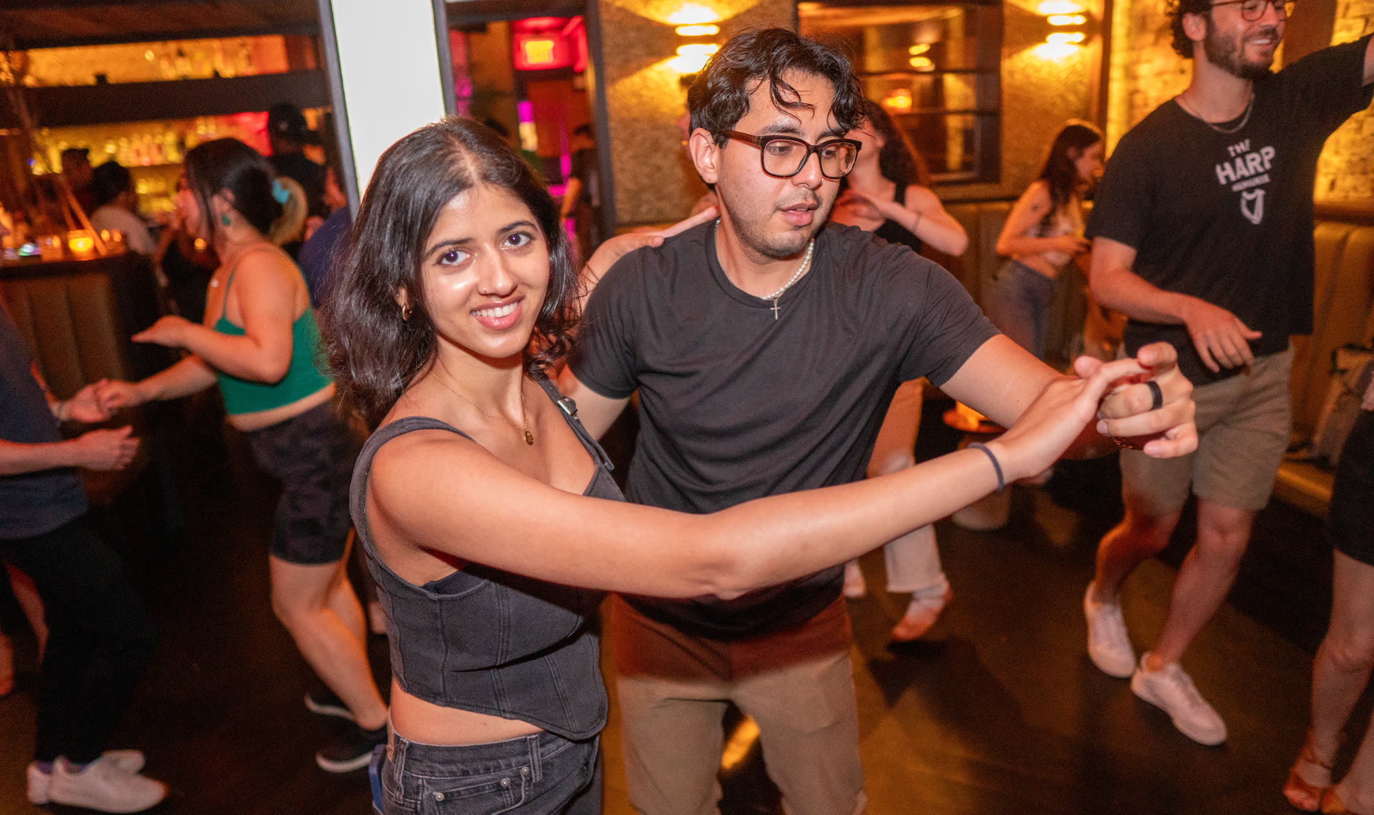 Salsa partners smiling on a Brooklyn dance floor